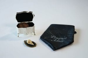 a Victorian-style trinket box, a vintage broach and an ornate handkerchief HBO The Nevers