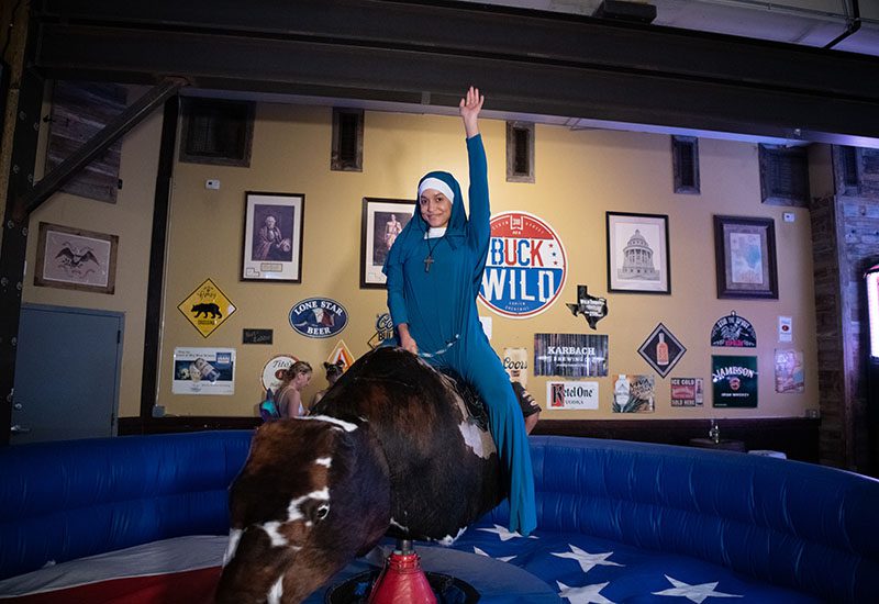 A nun rides a mechanical bull at Buck Wild in Austin
